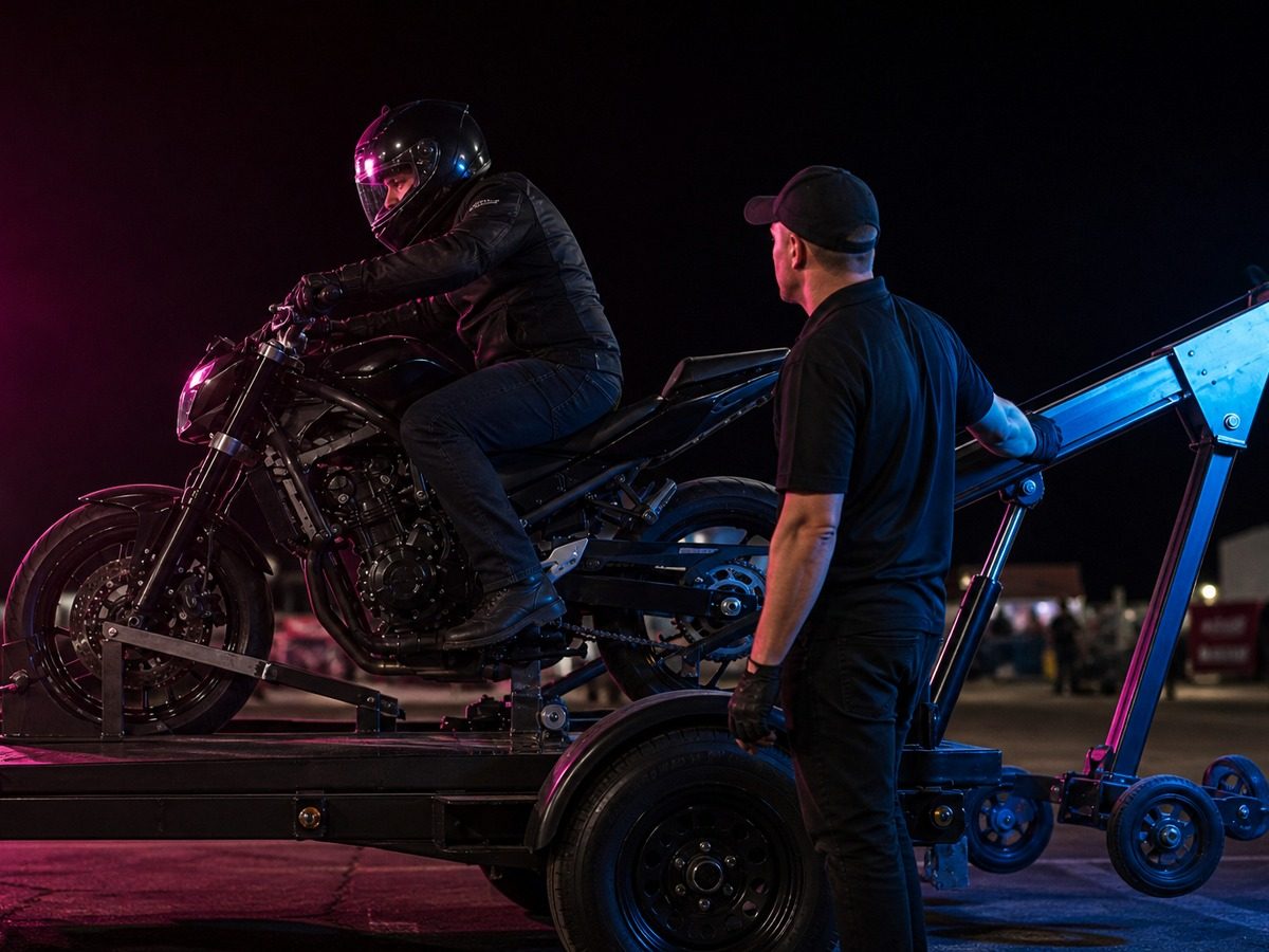 Wheelie machine bike clamped to the trailer boom with crew alongside